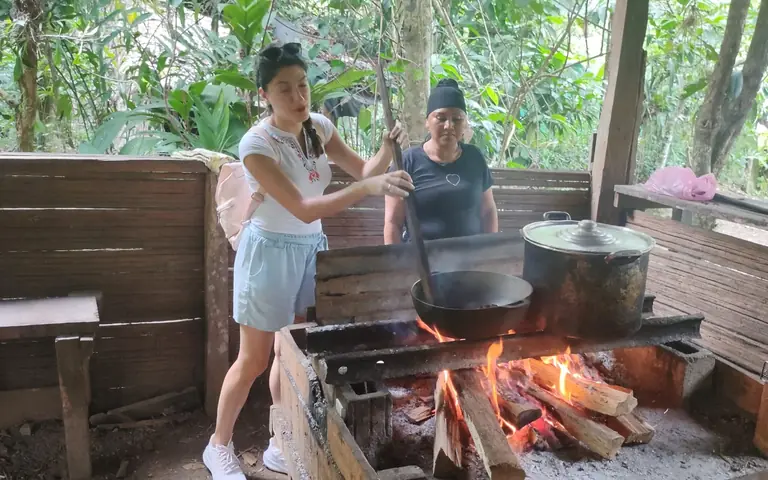 Cacao cooking in a pot over a wood fire under a rustic ranch